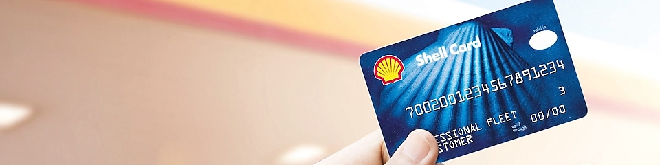 Blue shell fuel card being held between thumb and forefinger