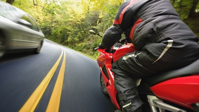 motorcycle on road curving through mountain landscape