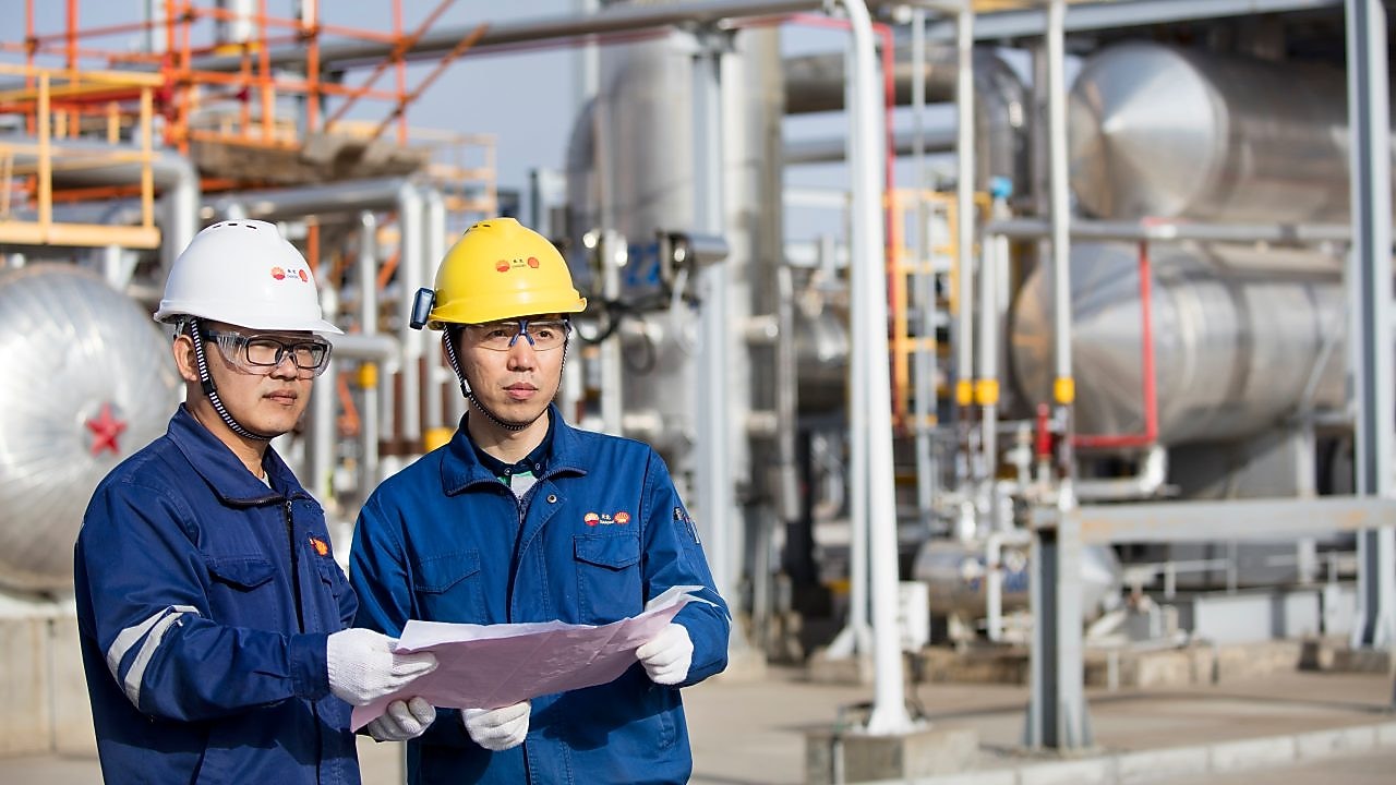 Operators reviewing refinery technology performance