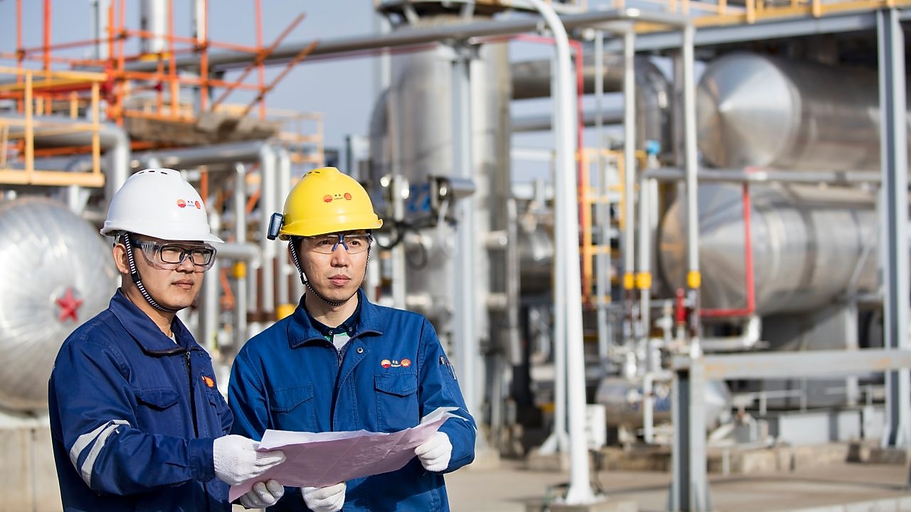 Operators reviewing refinery technology performance