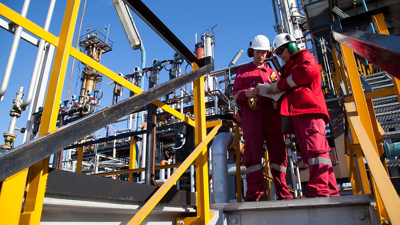 Two workers discuss catalysts reactions at Shell Argentina refinery