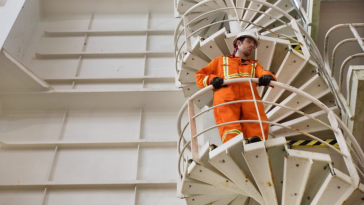 Worker watches from the stairs.