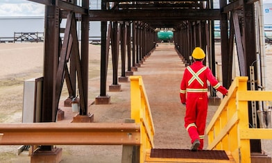 A Shell employee walking toward a reactor with FCC Catalysts.