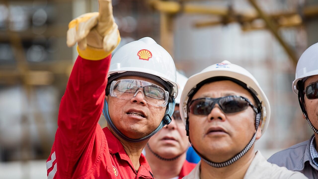 Employees reviewing LNG technology