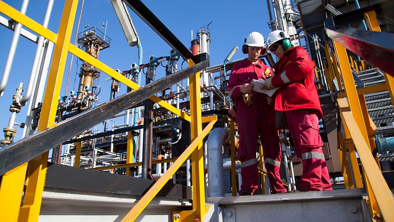 Two workers discuss catalysts reactions at Shell Argentina refinery