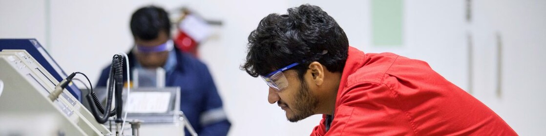 Researcher working on IH2 technology equipment in the Bitumen lab