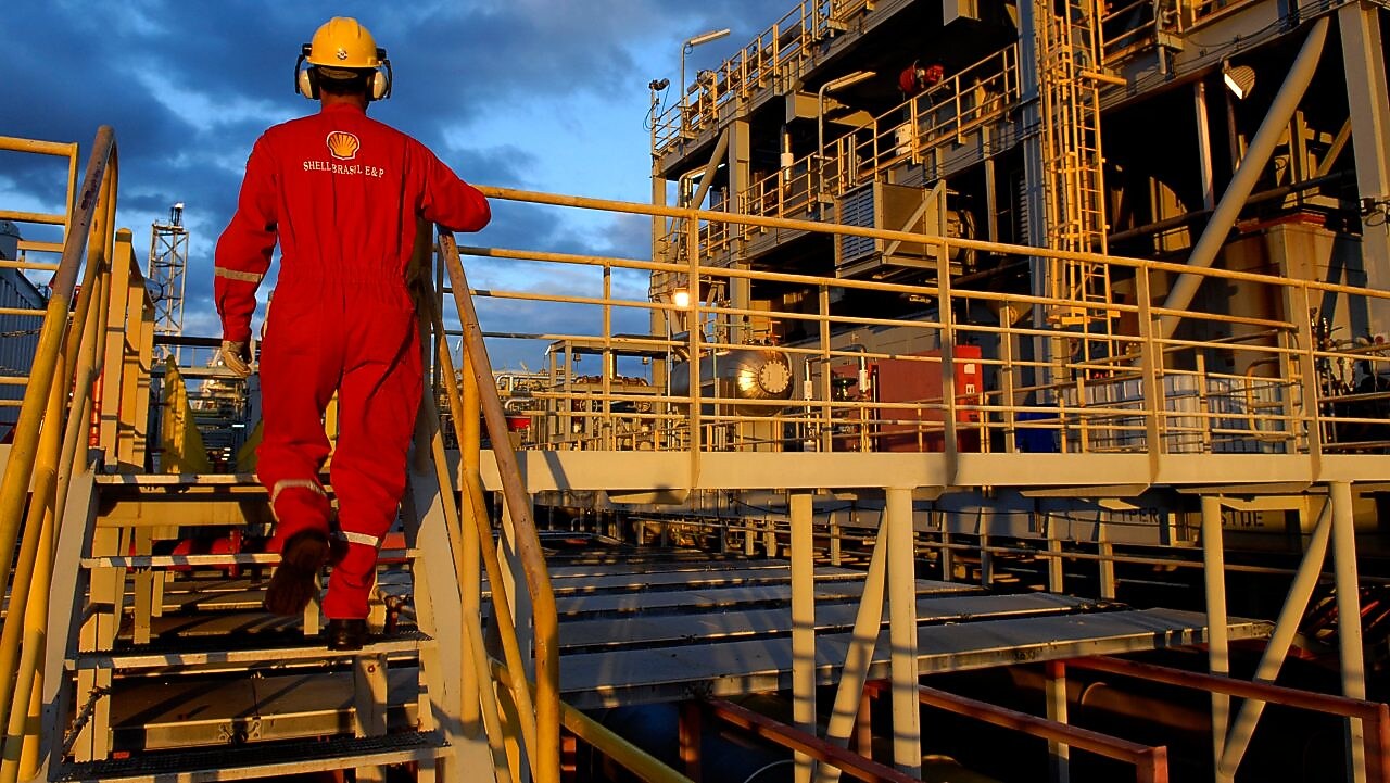 Worker walks up stairs in platform which utilizes waste to fuel technology
