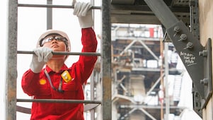 Refinery employee climbing a ladder
