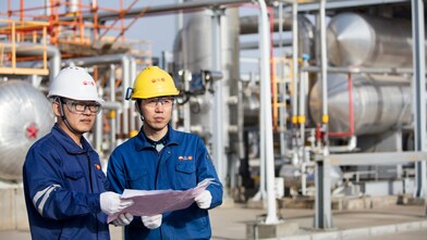 Operators reviewing refinery technology performance