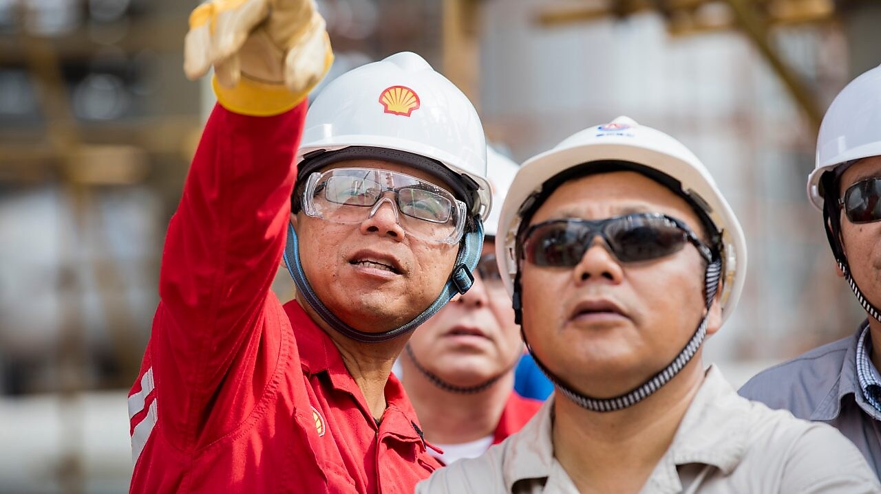 Employees reviewing LNG technology