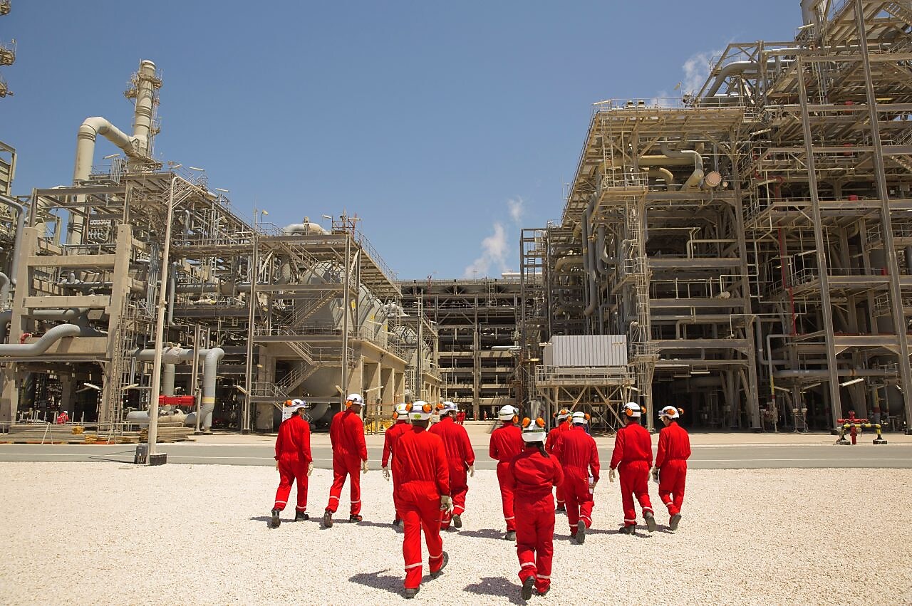 Amine gas treating engineers walk towards the Pre-treatment section of the gas-to-liquids area