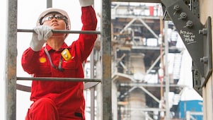 Worker climbs a ladder at a petrochemical plant