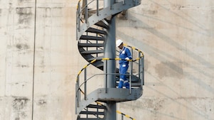 Worker descending the stairs of a LNG tank at hydrocracking facility