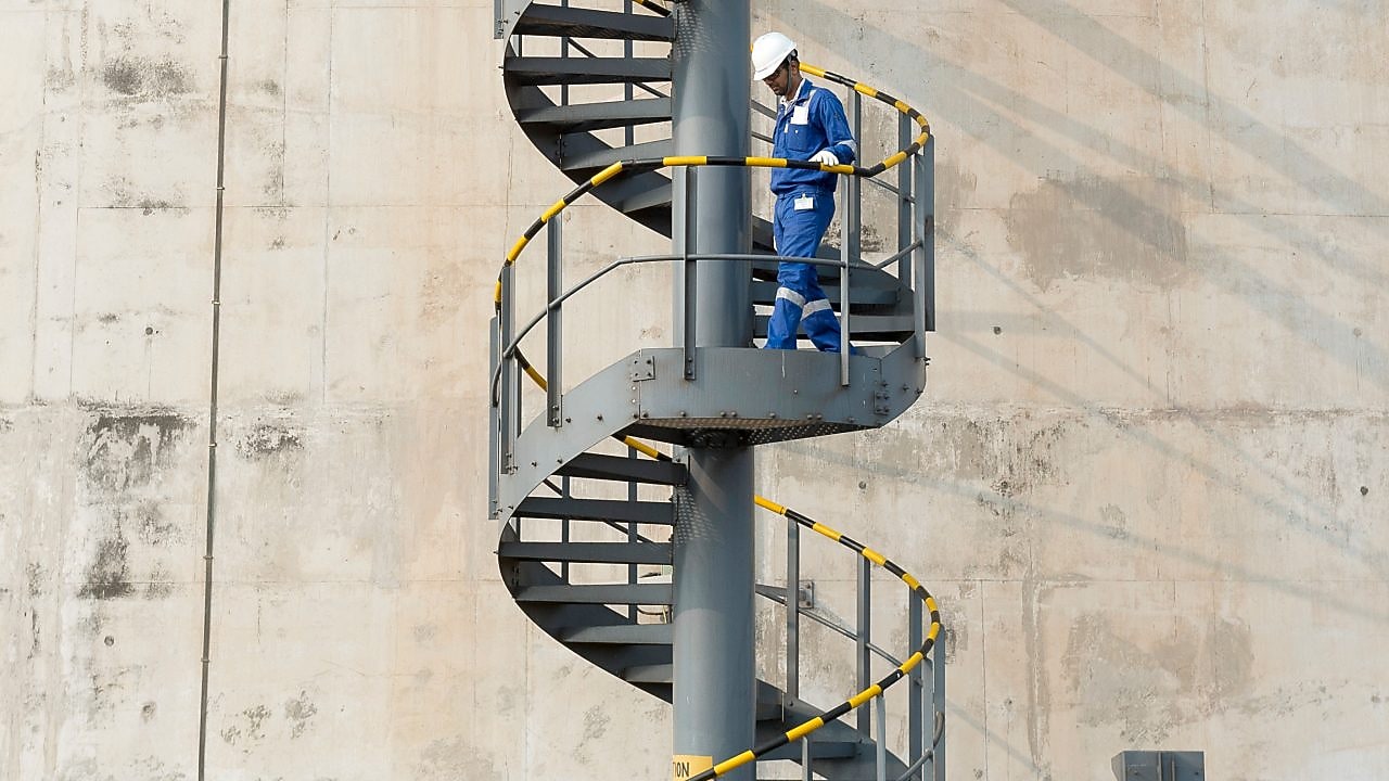 Worker descending the stairs of a LNG tank at hydrocracking facility