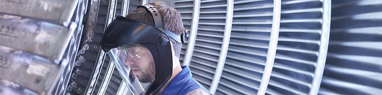 电力工程师正在修理工业涡轮机，让其高效运转。