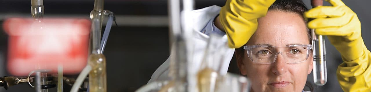 戴着护目镜正在实验室内进行实验的女士