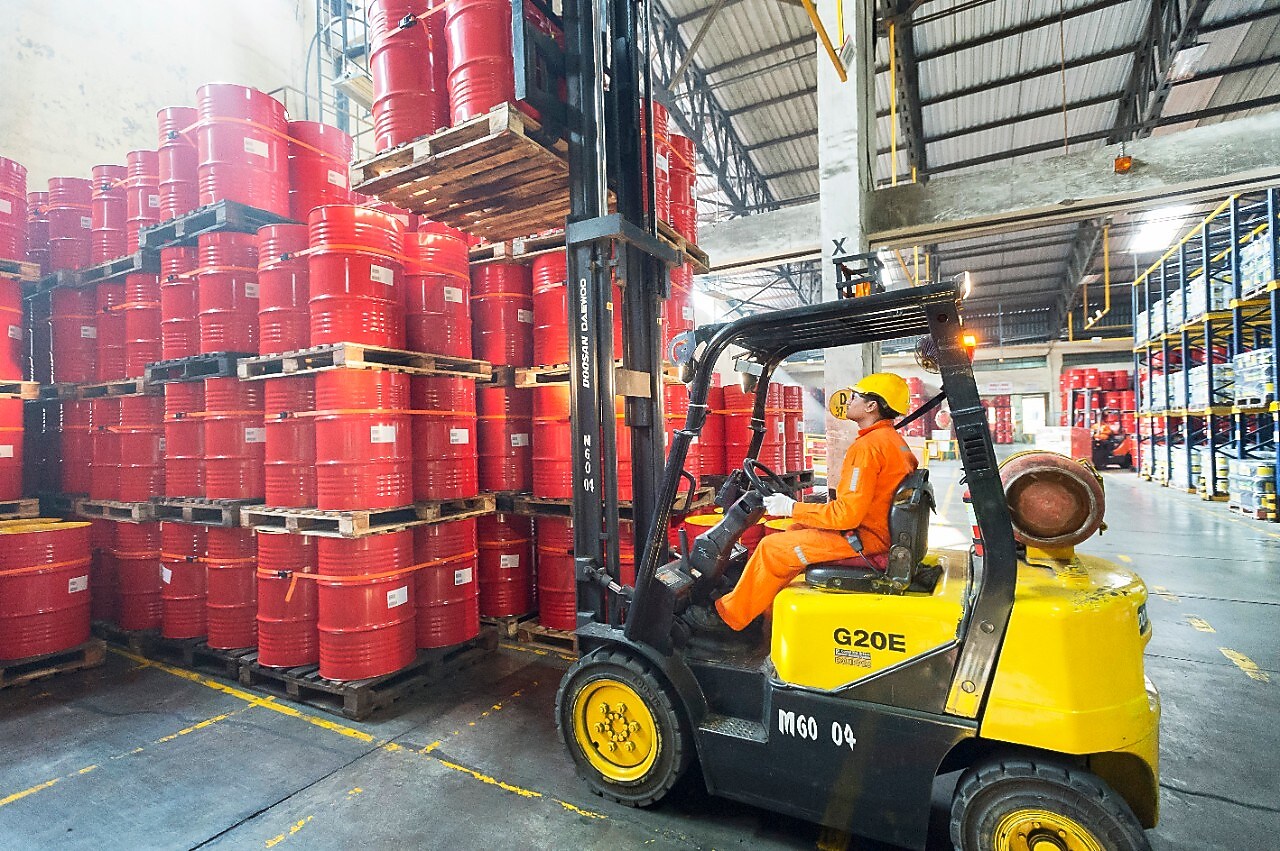 man forklifts lubricant barrels