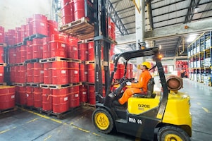 man forklifts lubricant barrels
