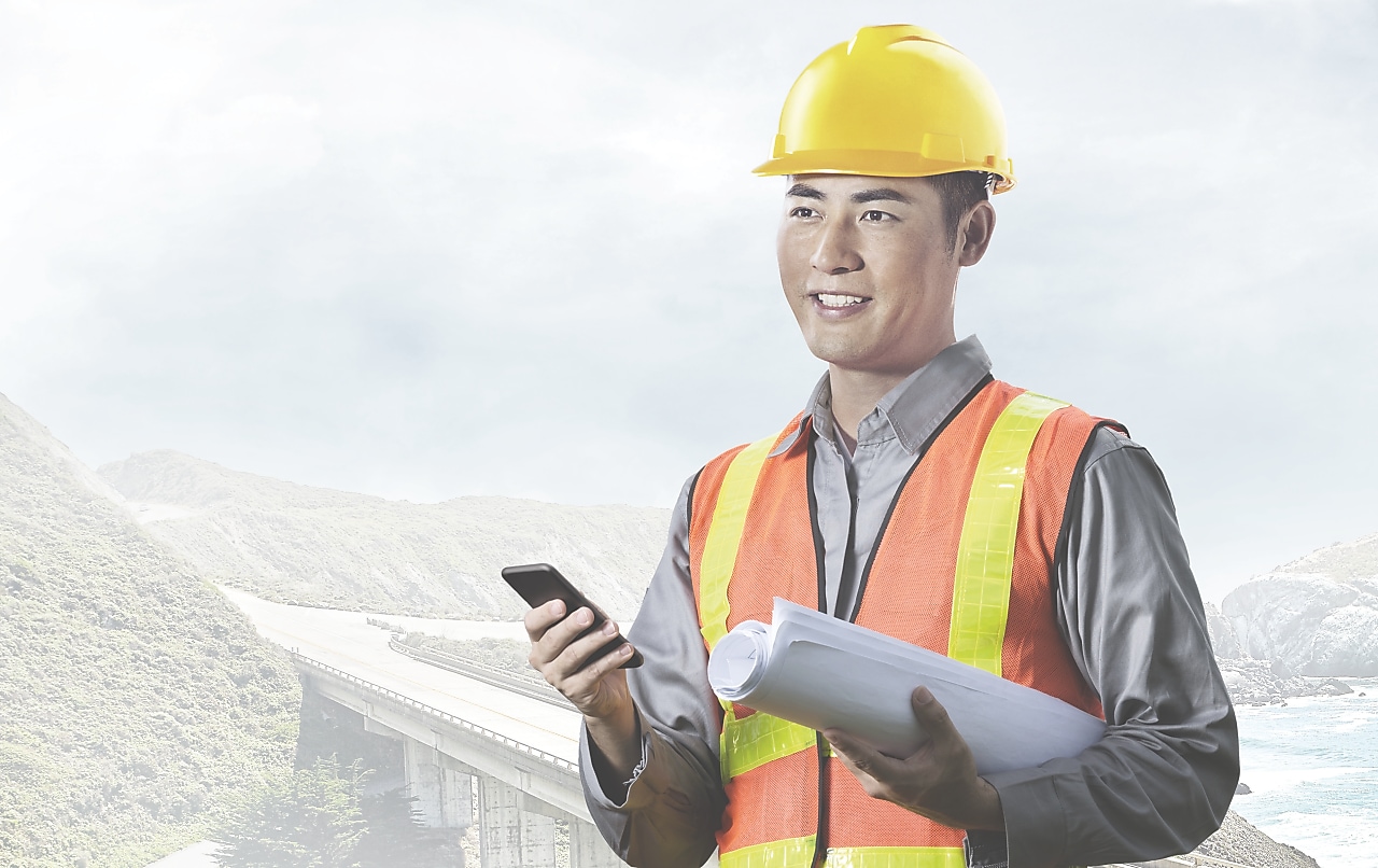 一名头戴黄色安全帽手握手机的男性