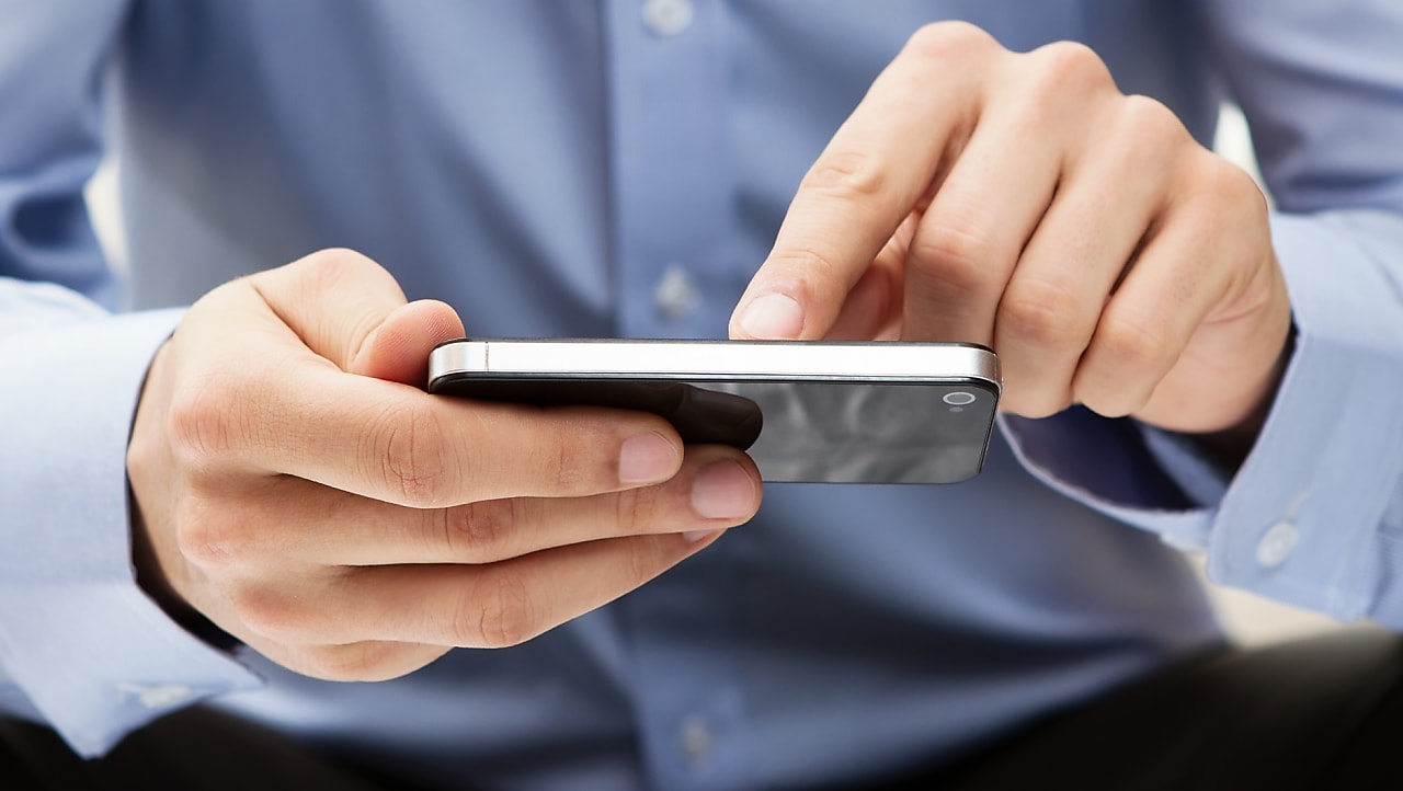 男人在他的手机上滑动手指