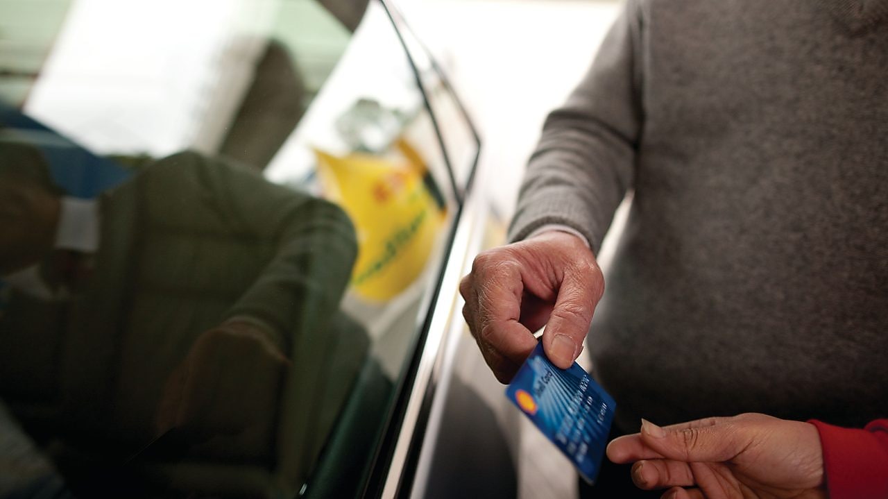 Man holding Shell card at Retail site