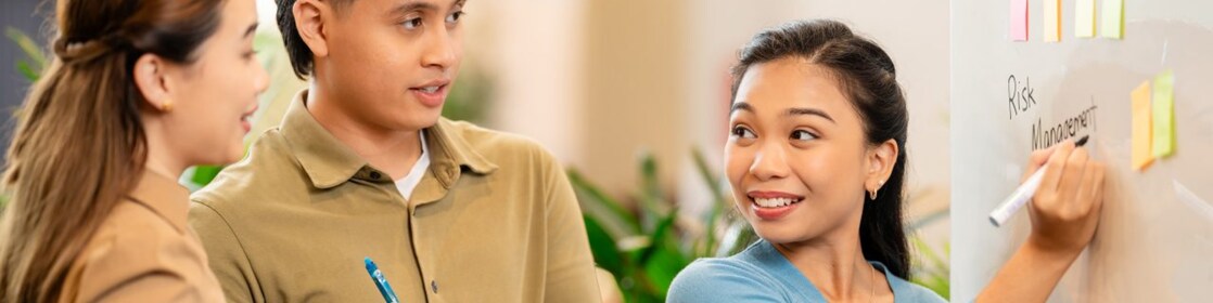 a female employee holding an ipad and looking somewhere with a smile
