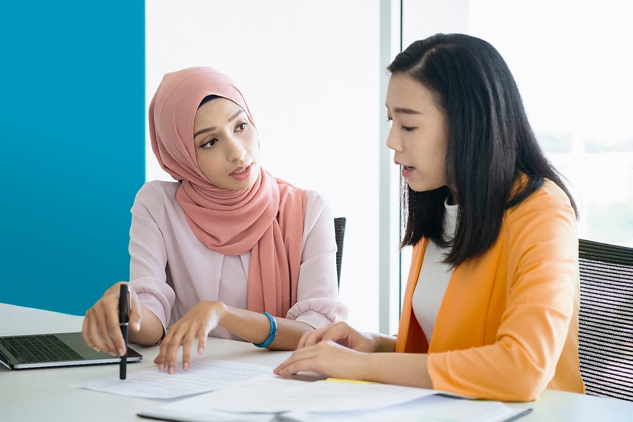 woman wearing hijab collaborating with colleague