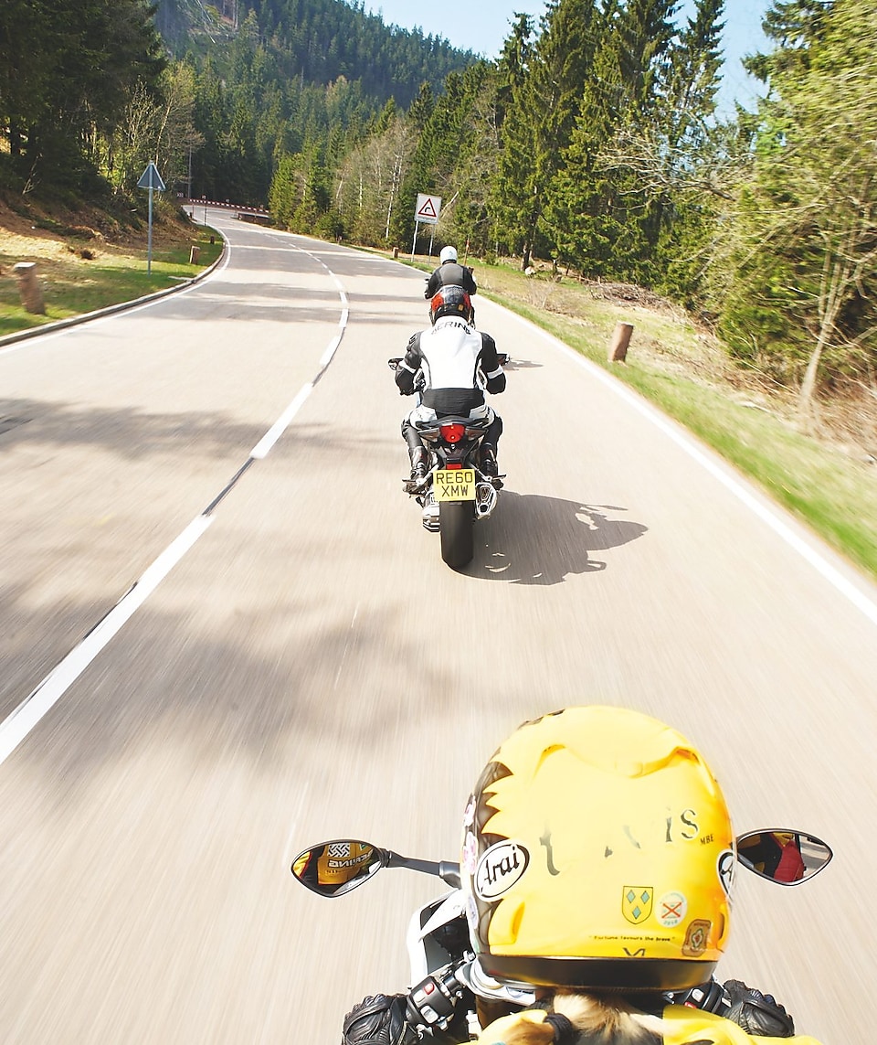 Three motorbikes being ridden along a mountain road