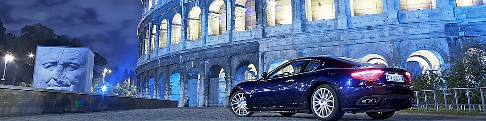 Car parked outside of the Colosseum in Rome at night