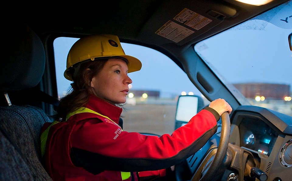 A lady wearing safety equipment driving a vehicle