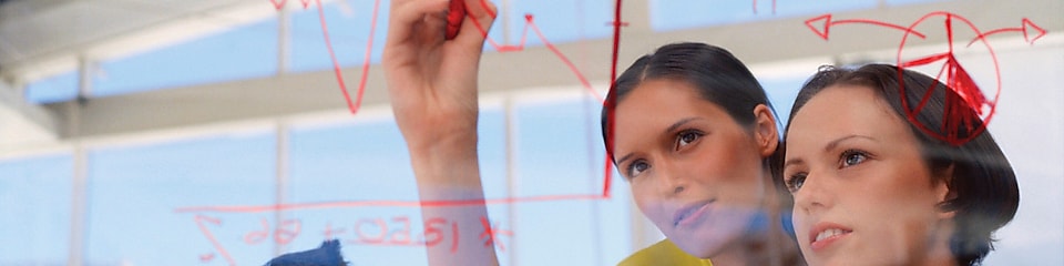 Businesswoman drawing graphs on glass