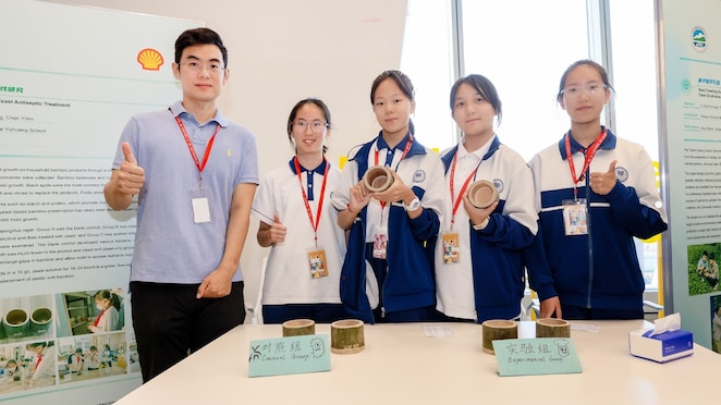 赵溪(左一)和他指导的学生们展示“竹材酵母防腐处理的可行性研究”
