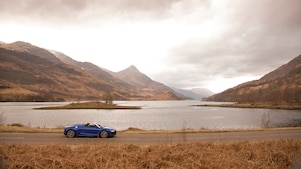 湖边行驶的蓝色轿车