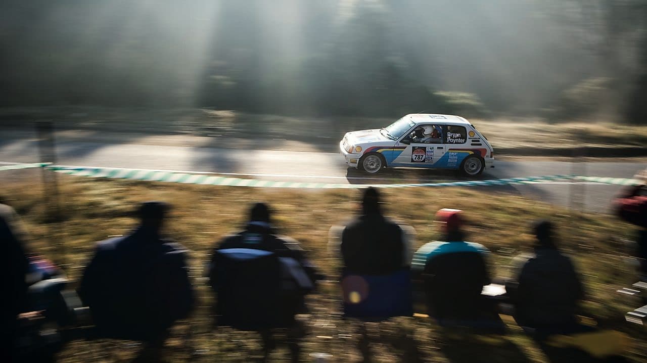 在观众的注视下飞驰在公路上的赛车