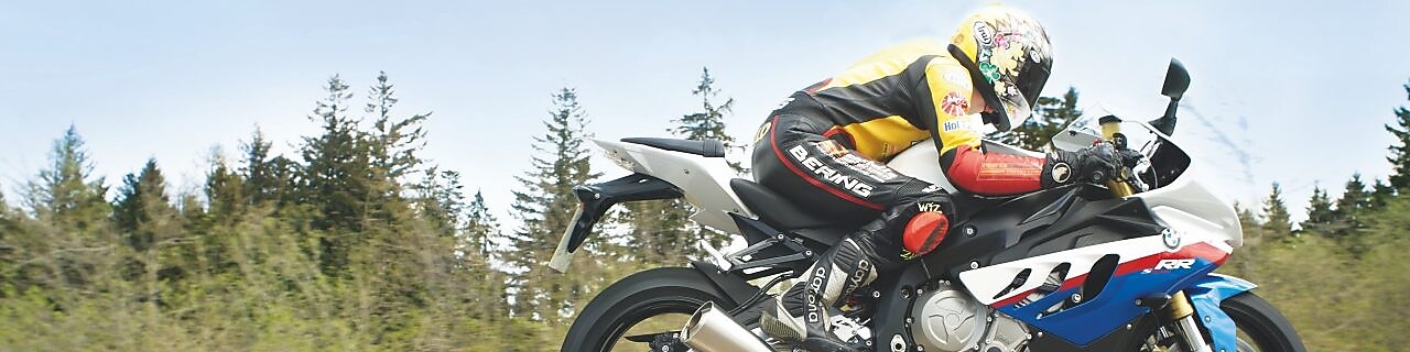 沿乡村公路驾驶摩托车的男子