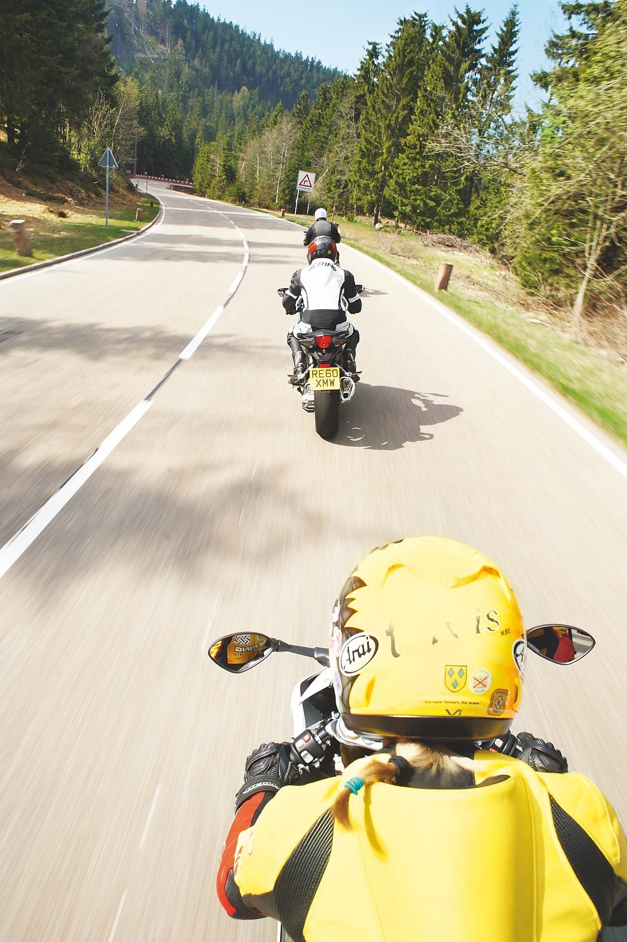 沿着山路相互追赶的三辆摩托车