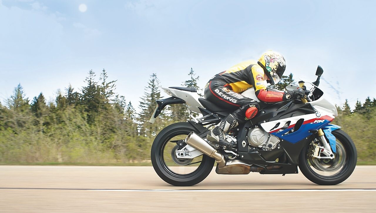 沿乡村公路驾驶摩托车的男子