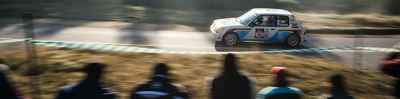 在观众的注视下飞驰在公路上的赛车