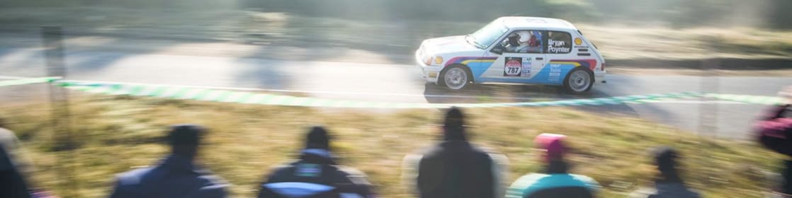 在观众的注视下飞驰在公路上的赛车