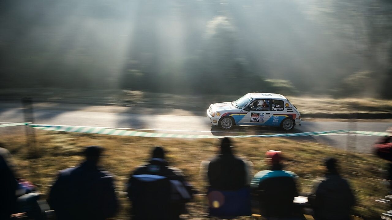 在观众的注视下飞驰在公路上的赛车