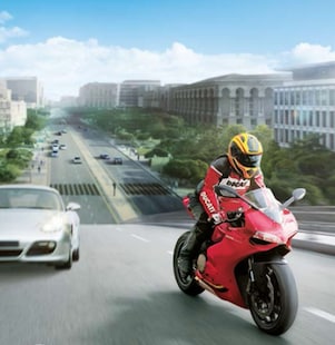 略过一辆辆汽车和一栋栋建筑的红色摩托车和车手