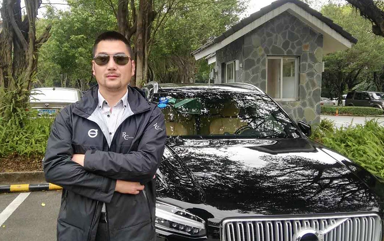 Chen Peng at standing in front of car