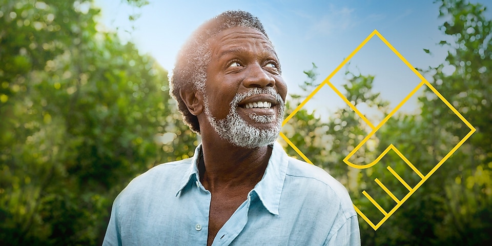 图片：一名蓄着胡子的男子微笑着站在树前，上面有“创造股东价值”的轮廓图