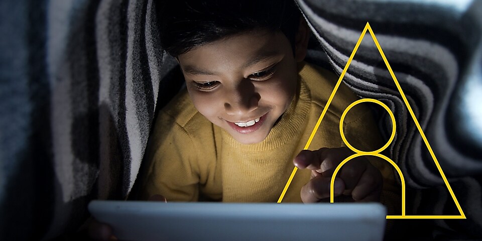 照片：一名小男孩正在看平板电脑，上面有“赋能生活”的轮廓图