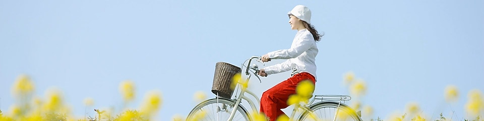 一个年轻女人骑单车穿过夏季的田野