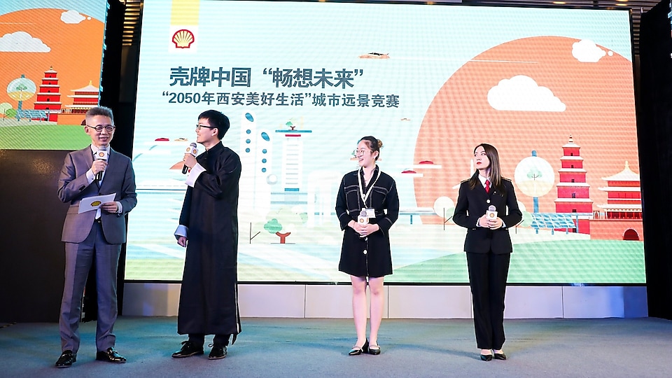 壳牌“畅想未来”远景挑战赛: 来自三所高校的学生团队(从左二起:西安交通大学学生代表,上海理工大学中英国际学院学生代表,中国民航大学学生代表)在台上与主持人蒋昌建互动