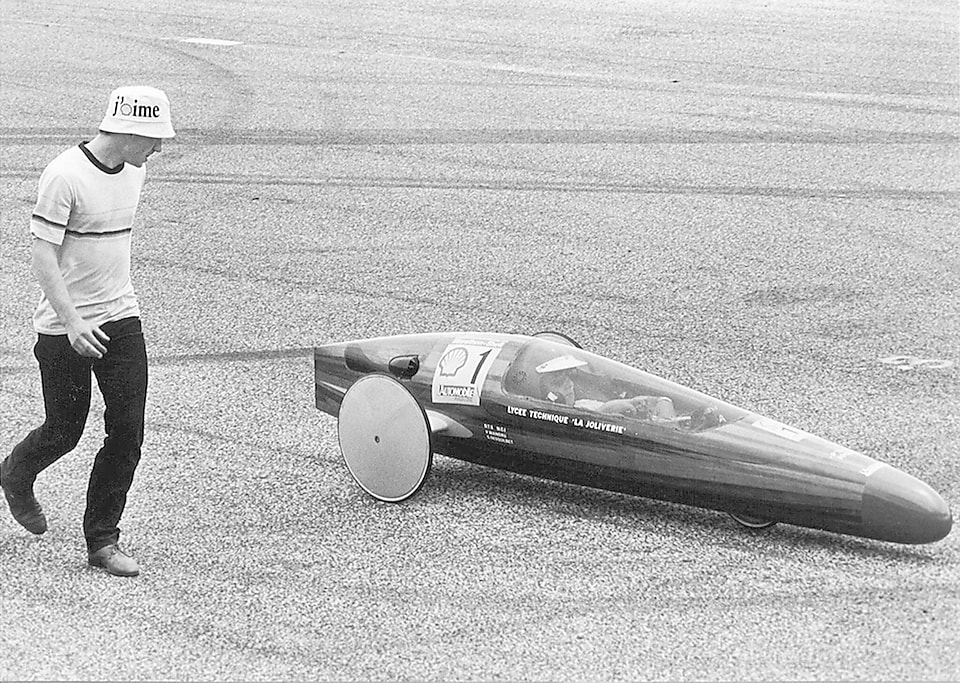 students with his prototype car on track.