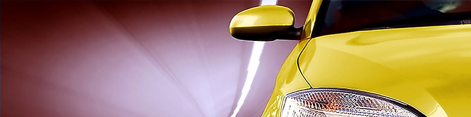 一辆穿过隧道的黄色汽车的正面照，可以看到右前侧的车灯和后视镜